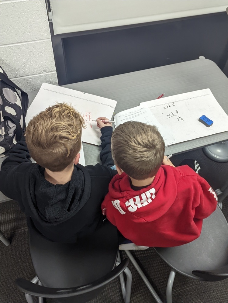 2 students working on classwork at a table