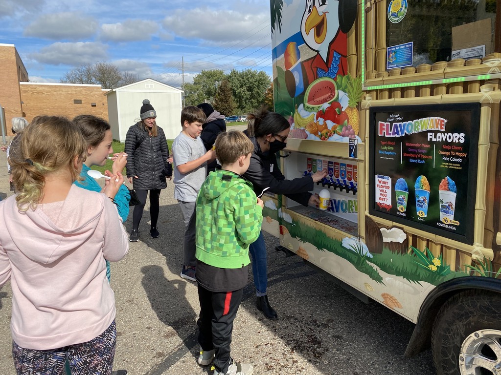 kids and parents getting frozen ice treats from kona ice truck