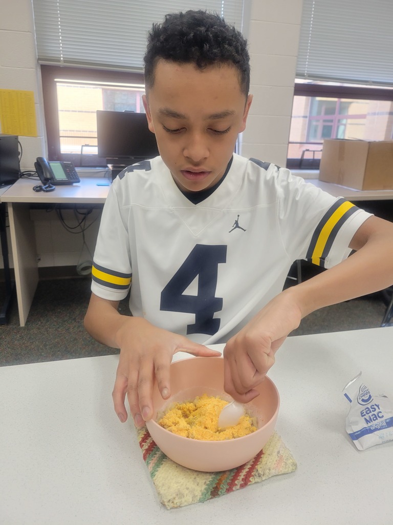 boy stirring macaroni and cheese