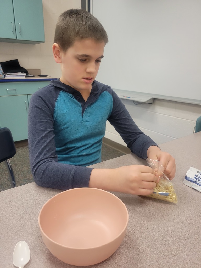 boy pouring macaroni and cheese
