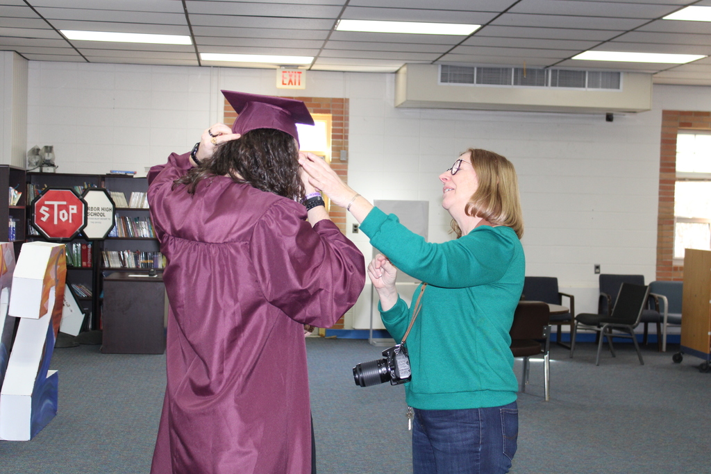 teacher helping student with cap and gown