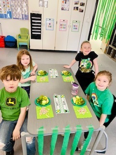 students eating green food in a classroom