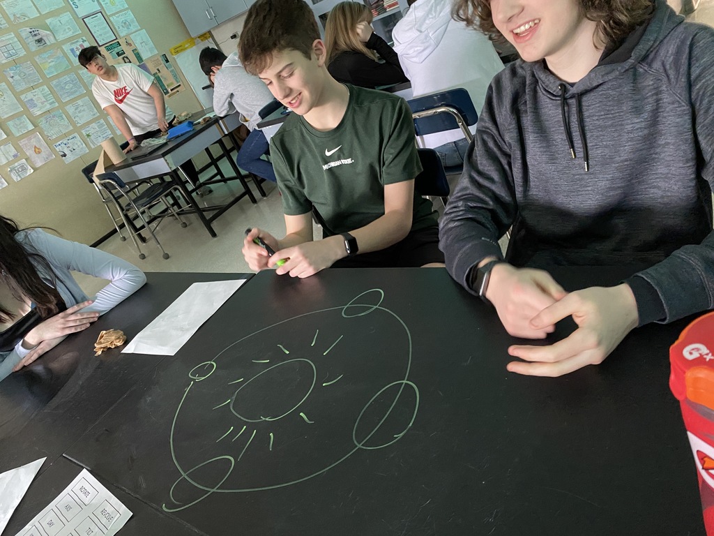 boys drawing on a science table