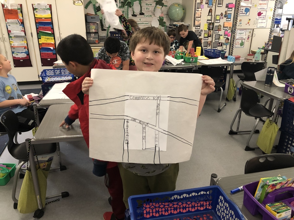 student holding up a map he drew