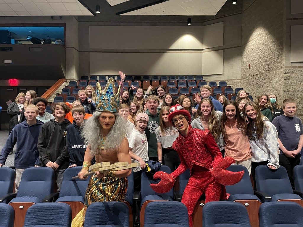 King Triton character with students in audience
