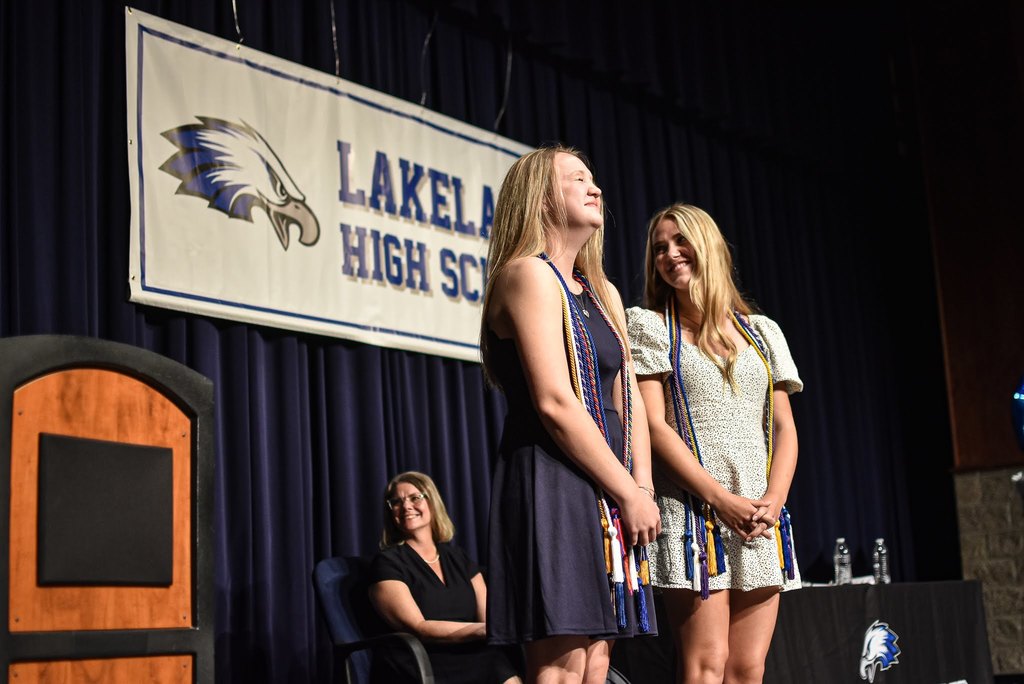 Two students laughing and enjoying honors night on stage