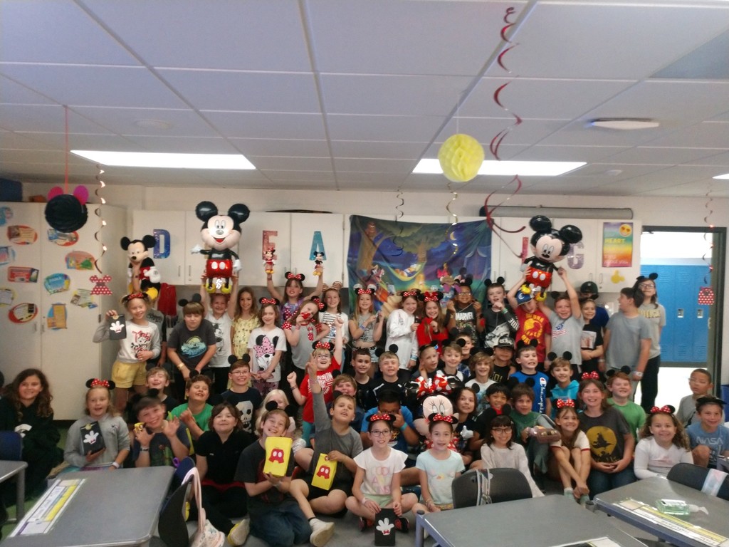 students in a classroom celebrating disney day with mickey ears and disney themed decorations