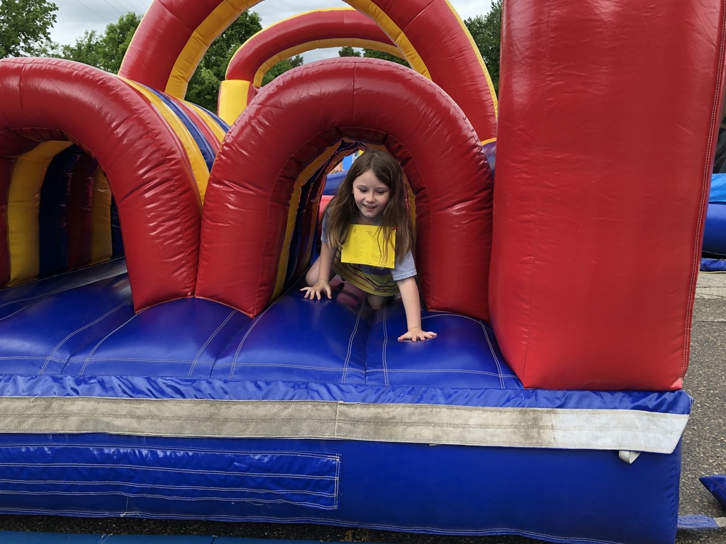 student coming out of bounce house obstacle course