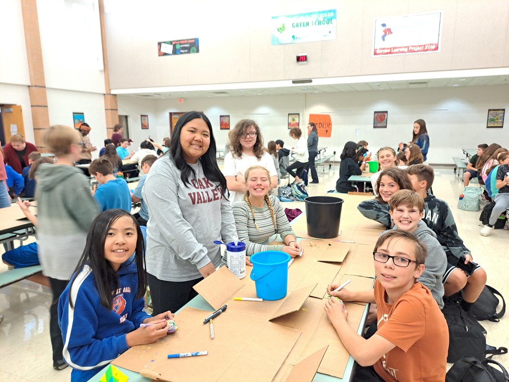 8th graders helping 6th graders paint rocks