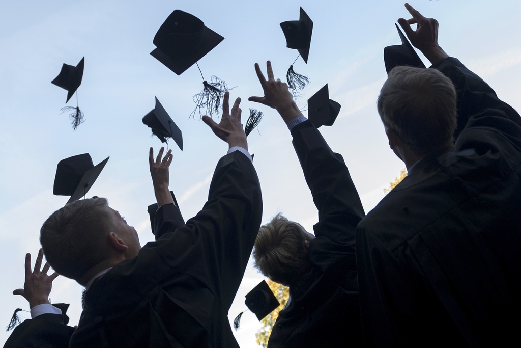 People throwing graduation caps