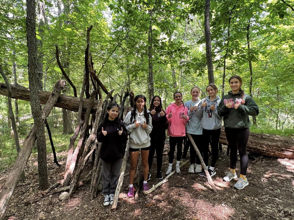 students give thumbs up in forest