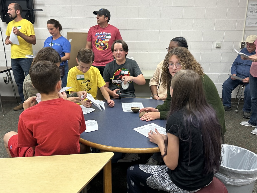 Robotics students talk around a table